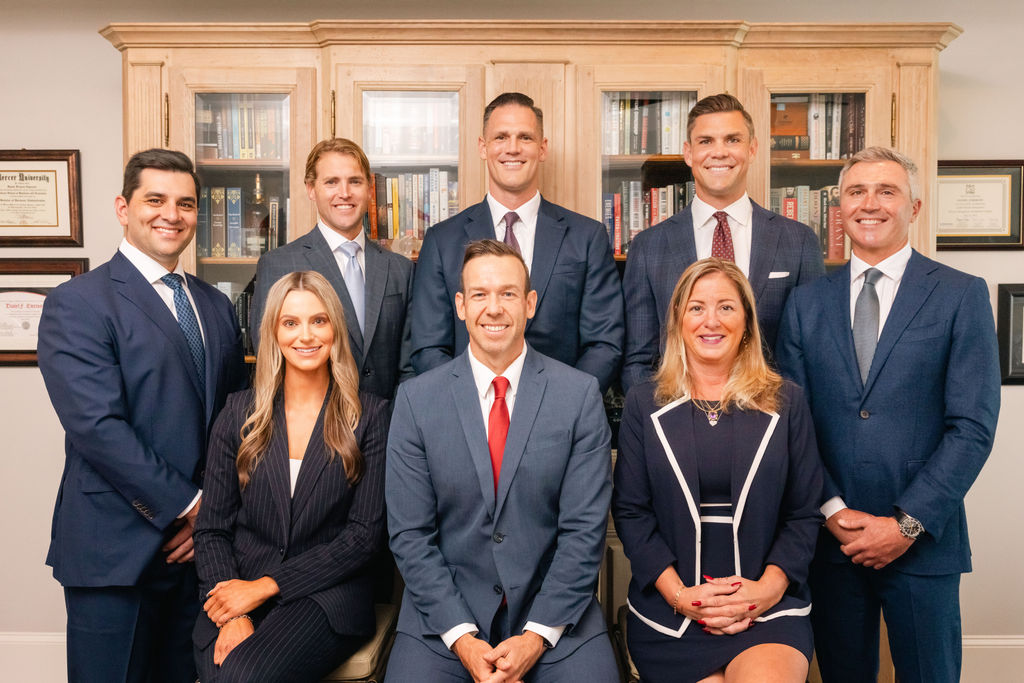 Harbor View Private Wealth Team poses for a group photo. 5 men are standing in the back with a woman, a man, and another woman sitting in front.
