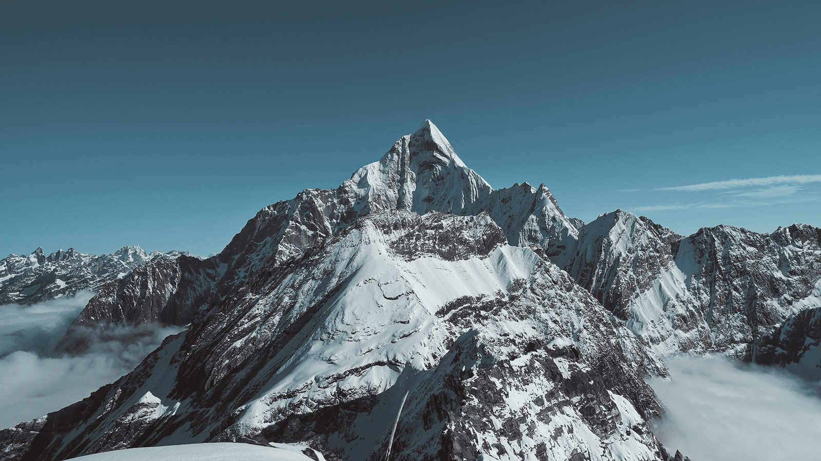 Snowy mountain peak with blue skies in the background