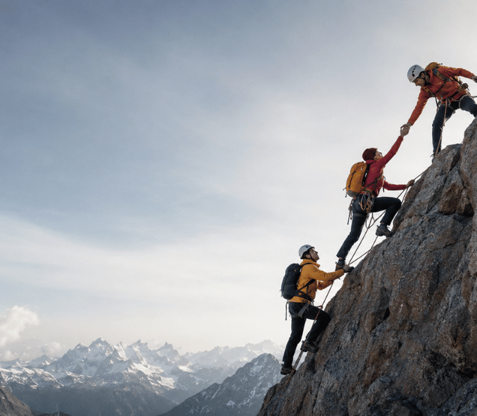 3 mountain climbers climbing a mountain